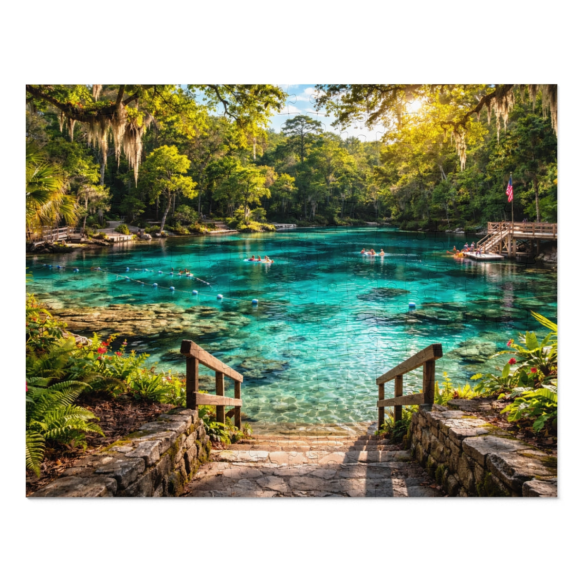 Clear blue water pool with people swimming surrounded by greenery and a wooden dock.