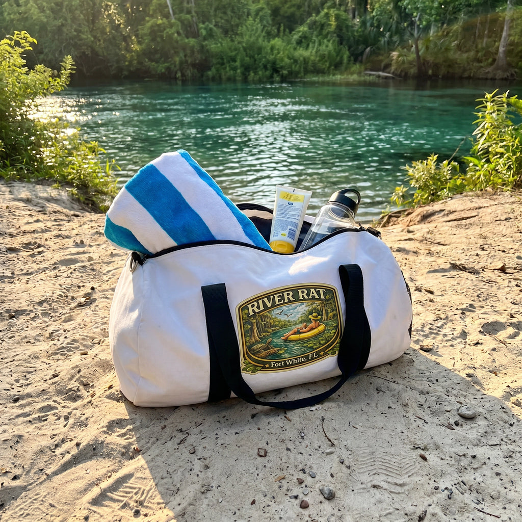 River Rat Duffel Bag flat-lay on sandy riverbank